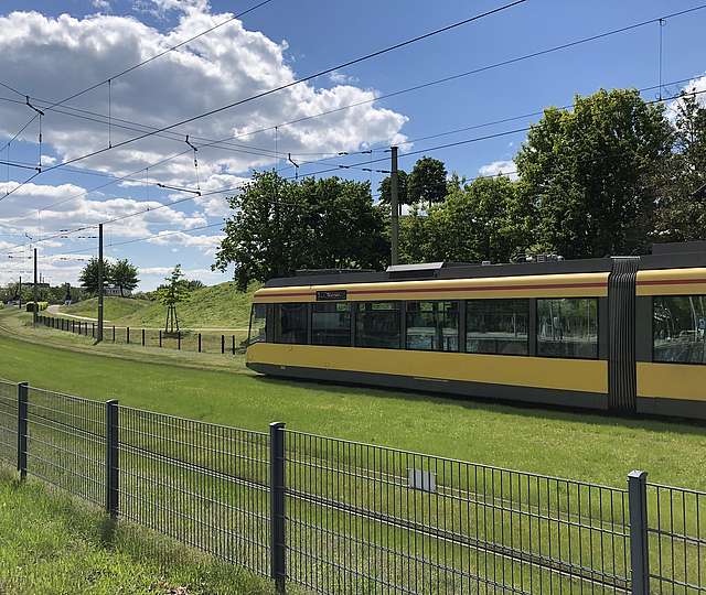 Eine Bahn fährt im grünen Umland.