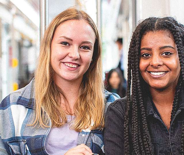 Zwei junge Teenager-Mädchen sitzen in der Bahn.